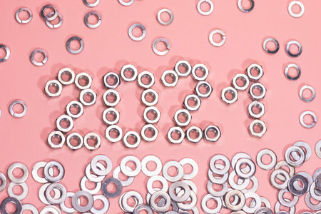 Number 2021 on pink paper. Nuts are in the form of numbers. Metal nuts. washers and grovers....