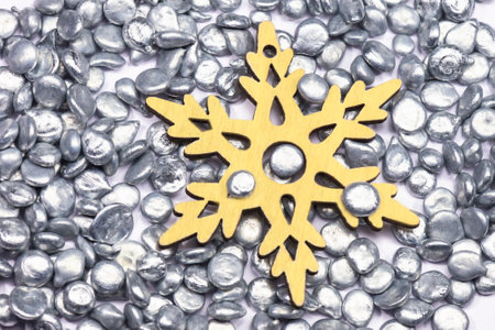 Snowflake made of plywood on metal zinc granules. Symbol of the New year. Top view. Industrial background. Color of the year 2021, illuminating and ultimate gray.の写真素材