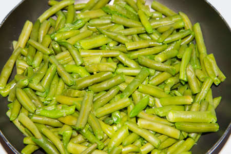 Delicious fresh green beans on a frying pan. Vegan food preparation. Angular view.の写真素材