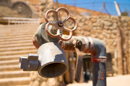 Fire safety in a country with a hot climate. Fire hydrant pipe with red valve. Protecting tourists on the beach from fire.の写真素材