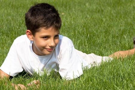 a boy is smiling on the green grassの写真素材