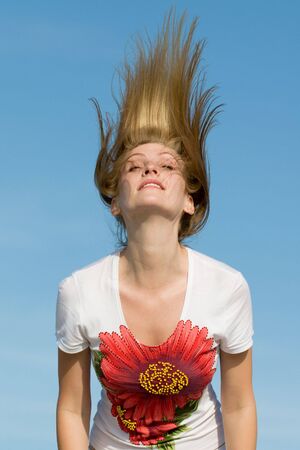 a girl is playing with her hair outdorsの写真素材