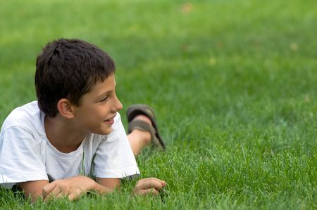 a boy is smiling on the green grassの写真素材