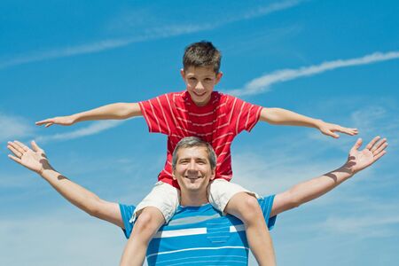a father and his son are enjoying life outdoorsの写真素材