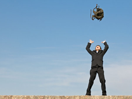 a successful student is throwing his lucky schoolbag up