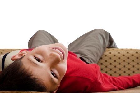 a boy in red pullower is lying on the sodaの写真素材