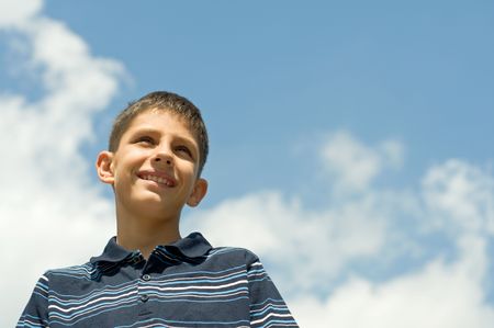 a boy is dreaming at the cloudsの写真素材