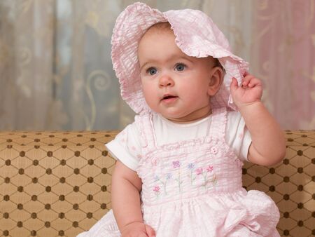 a portrait of a baby in pink suit and hatの写真素材