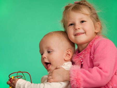 Two smiling playing kids are on the green backgroundの写真素材