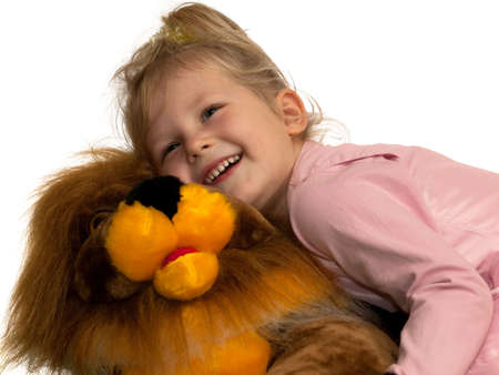 Little girl is playing with a toy lionの写真素材