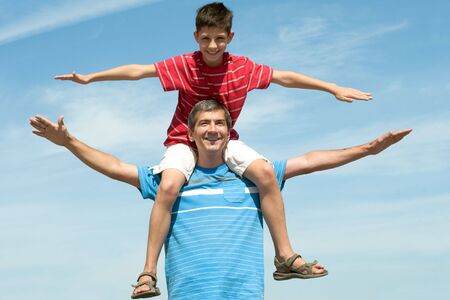 Happy father and his son are enjoying life outdoorの写真素材