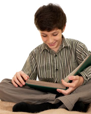 An attentive boy is reading a bookの写真素材