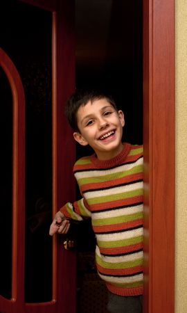 A smiling boy is standing at the doorwayの写真素材