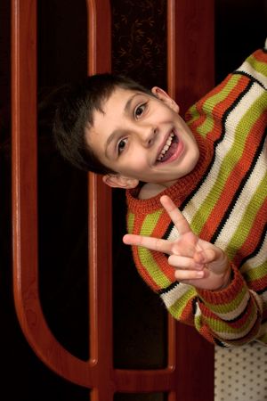 A happy boy is looking out of the doorwayの写真素材