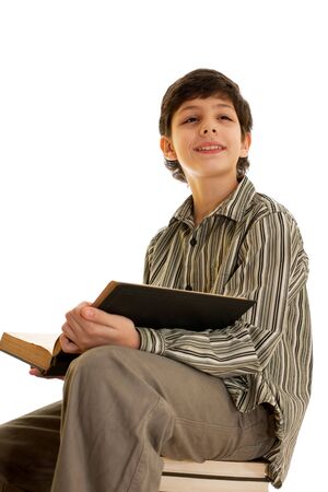 A smart boy is reading an encyclopedia, isolated on the white backgroundの写真素材