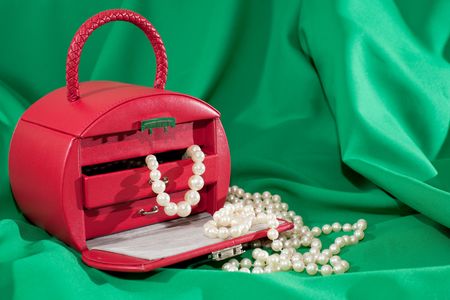 A red case with jewels is on the green backgroundの写真素材