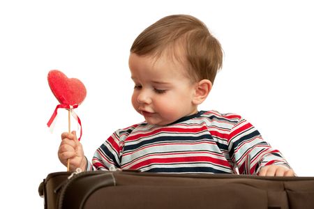 A kid is taking his first valentine out of the suitcase; isolated on the white backgroundの写真素材
