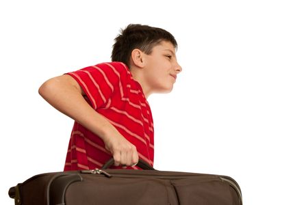 A boy is holding heavy luggage; isolated on the white backgroundの写真素材