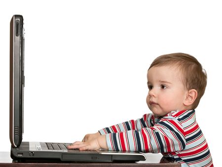 A toddler is working with a laptop, isolated on whiteの写真素材