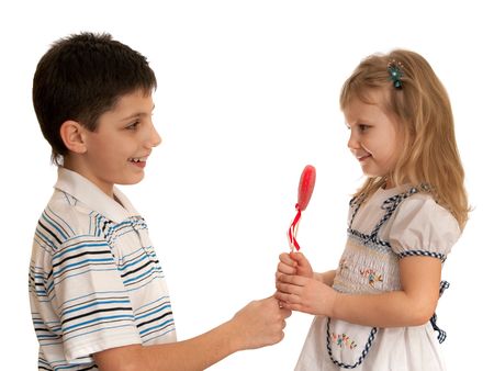 A boy is presenting a valentine to a girl; isolated on the white backgroundの写真素材