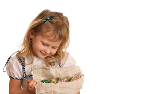 A girl is holding a basket with Easter eggs; isolated on the white backgroundの写真素材