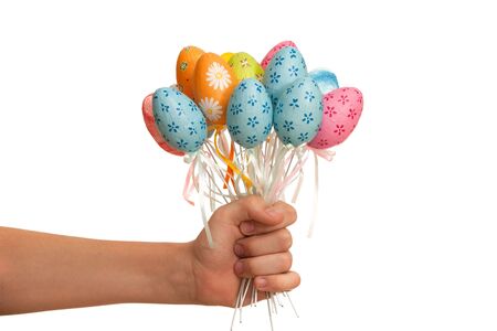 A hand holding a bounch of easter colored eggs; isolated on the white backgroundの写真素材