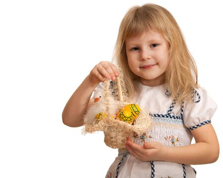 A little girl is holding a basket with Easter eggs and chick; isolated on the white backgroundの写真素材