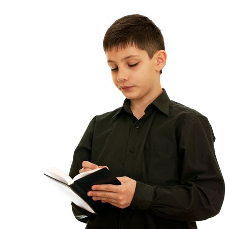 A confident teen is writing in the notebook; isolated on the white backgroundの写真素材