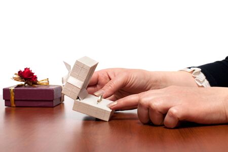 A white box with a wedding ring in women's handsの写真素材