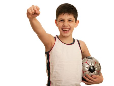 A happy kid is holding his right fist above his head and a ball in his left hand; isolated on the white backgroundの写真素材