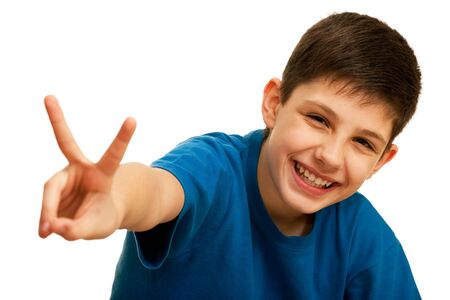 A portrait of a happy kid in blue showing a victory sign; isolated on the white backgroundの写真素材