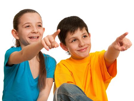 Two smiling children are pointing a distant object; isolated on the white backgroundの写真素材