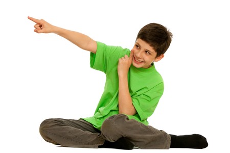 A boy in green is pointing up and wispering secretly; isolated on the white backgroundの写真素材
