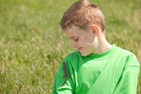 A lizard is on the shoulder of a smiling boyの写真素材