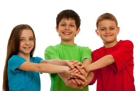 Three happy kids are holding their hands together ; isolated on the white backgroundの写真素材