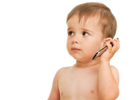 A serious toddler is speaking over the mobile; isolated on the white backgroundの写真素材
