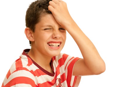 A boy  suffer with a headache is holding his head; isolated on the white backgroundの写真素材