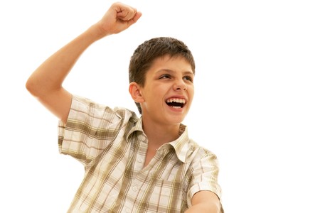 A happy kid is holding his right fist above his head; isolated on the white backgroundの写真素材
