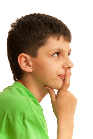 A portrait of curious handsome boy holding a finger on his lips; isolated on the white backgroundの写真素材