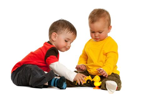 Two children are playing with blocks; isolated on the white backgroundの写真素材