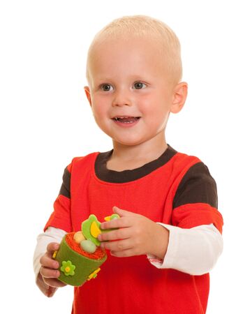 A toddler is holding easter toy; isolated on the white backgroundの写真素材