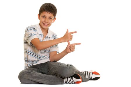 A handsome boy is pointing up; isolated on the white backgroundの写真素材