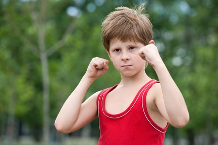 A young boy is standing in the fighting pose outdoorの写真素材