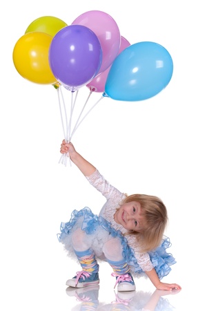 A cheerful laughing kid in blue is playing with baloons; isolated on the white backgroundの写真素材