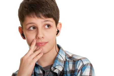 A cheerful boy in blue with headphones in the ears is listening to music; isolated on the white background の写真素材