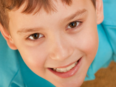 An extreame closeup portrait of a smiling boy; focus on the eyes