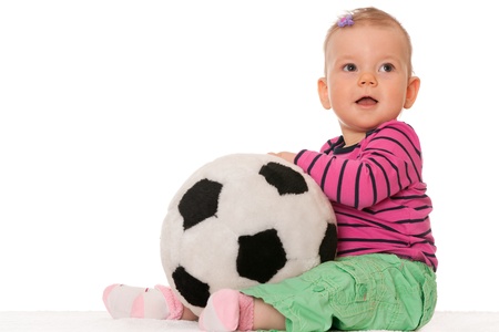 A cheerful baby girl is holding a big toy ball; isolated on the white backgroundの写真素材