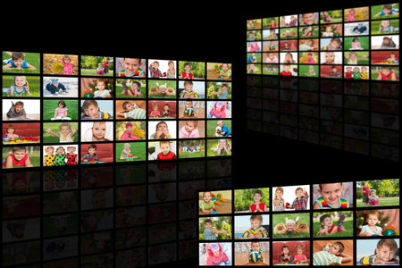 Diverse children portraits broadcast on huge displays located on the black background. All pictures...