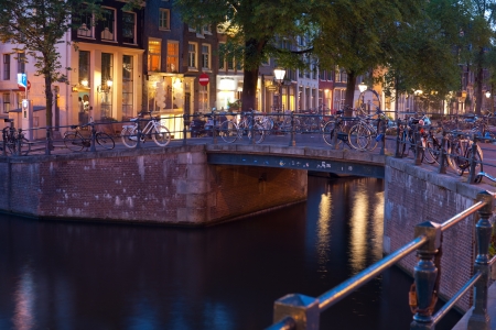 Amsterdam, Netherlands - May 27, 2012: Bicycles on the bridge over an Amsterdam canal at night. More than 60% of trips in the center of Amsterdam are made by bike. GPS information is in the file.のeditorial素材