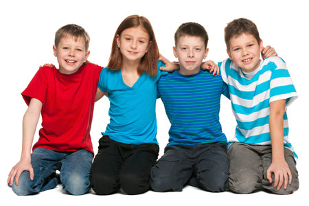 Group of four children are sitting on the floor on the white background